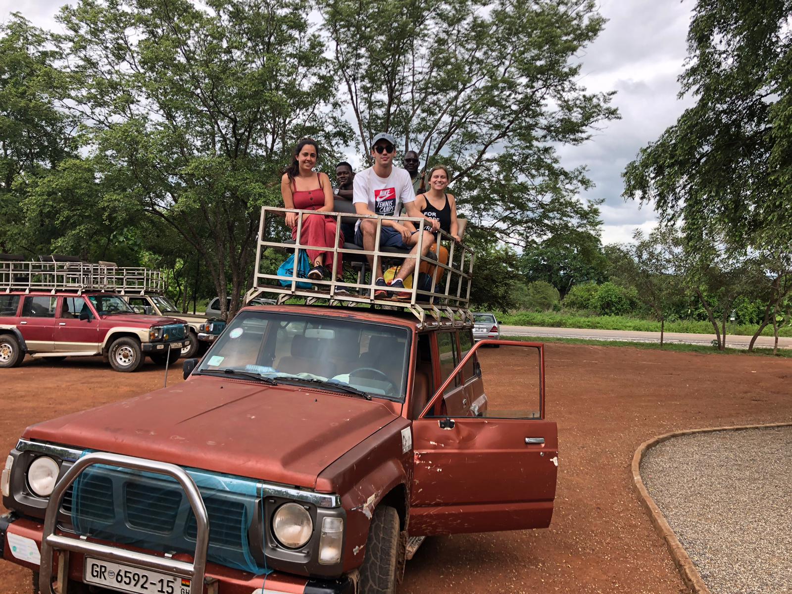 people on top of touring vehicle